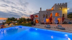 A stone building with a pool, outdoor seating, and a view of the sunset. - Once Upon a Time - A Castle of Magical Sunsets (Kalamata)