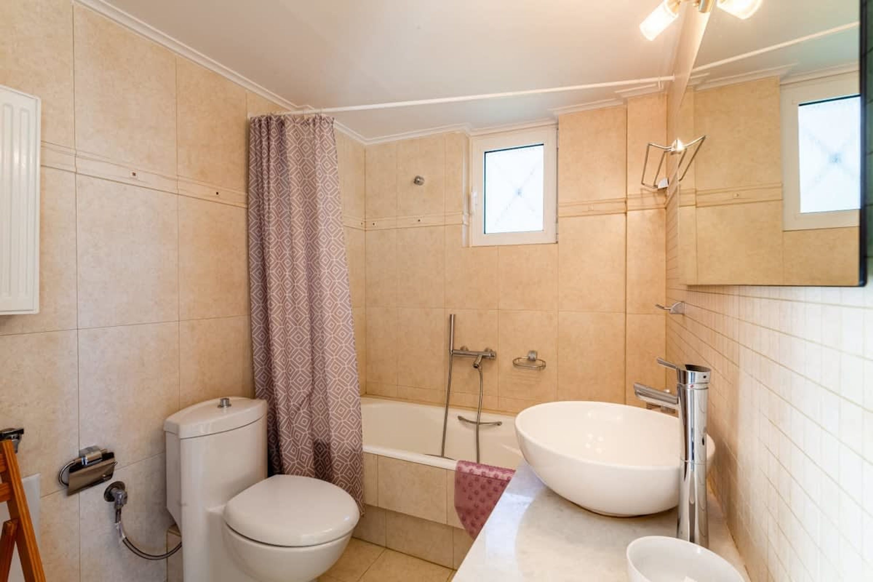A bathroom with a toilet, a bathtub, and two sinks.