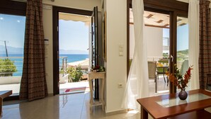 Ein Hotelzimmer mit Balkon, Essbereich und Meerblick.