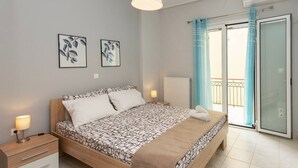 A modern bedroom with a bed, bedside tables, and artwork on the wall. - Thano s Stylish Flat Just 150m to the Beach (Kalamata)