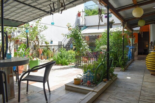 Relax in the serene patio area surrounded by lush greenery and a tranquil atmosphere.