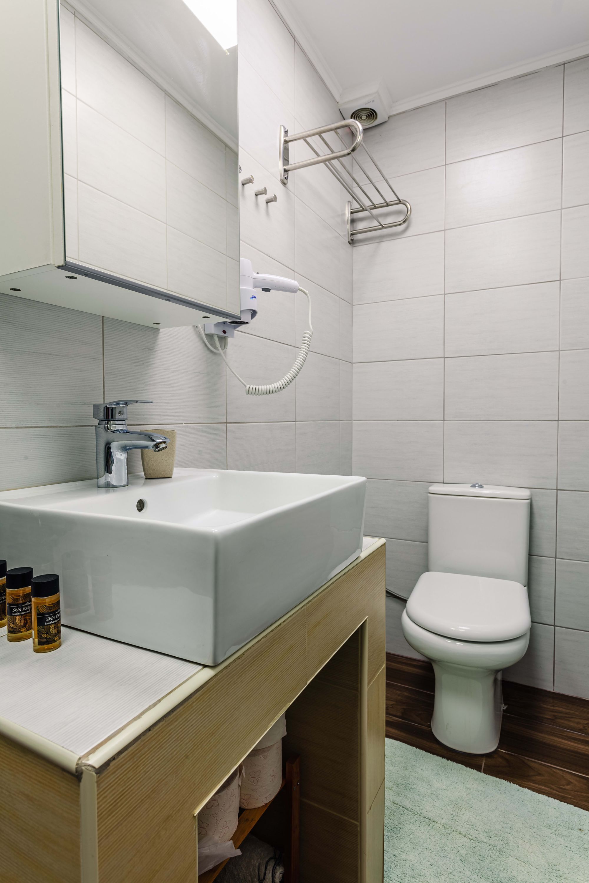 Ein modernes Badezimmer mit einem weißen Waschbecken, einer Toilette und einer Dusche.