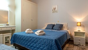 A bedroom with a bed, bedside tables, a wardrobe, and a wall-mounted lamp.