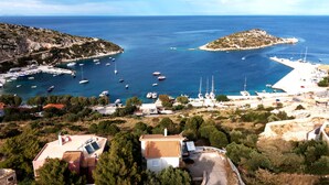 A coastal area with boats docked at a marina, a small island, and buildings with solar panels. - Coastal Paradise Found - Komis Private Pool Gem (Zakynthos)