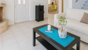 A living room with a white sofa, a coffee table with a plant, and a staircase. - Coastal Paradise Found - Komis Private Pool Gem (Zakynthos)