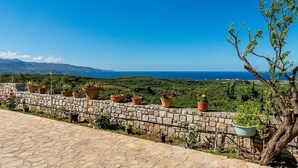 A stone wall with potted plants and a view of the sea. - Sea Breeze Stunning Views - Pool Dream Gem (Platanias)