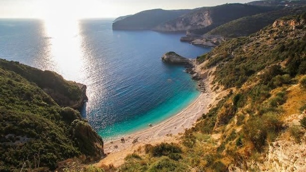Un paysage côtier avec une plage, des falaises et une vue dégagée sur la mer.