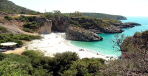 A coastal beach with rocky cliffs, clear turquoise water, and a sandy shore. - Mani s Garden Paradise - Elia Secluded Retreat (West Mani)