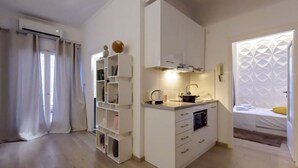 A compact kitchen with white cabinetry, a built-in oven, and a small countertop. - City Skyloft - Top Location Private Roof Garden (Kalamata)