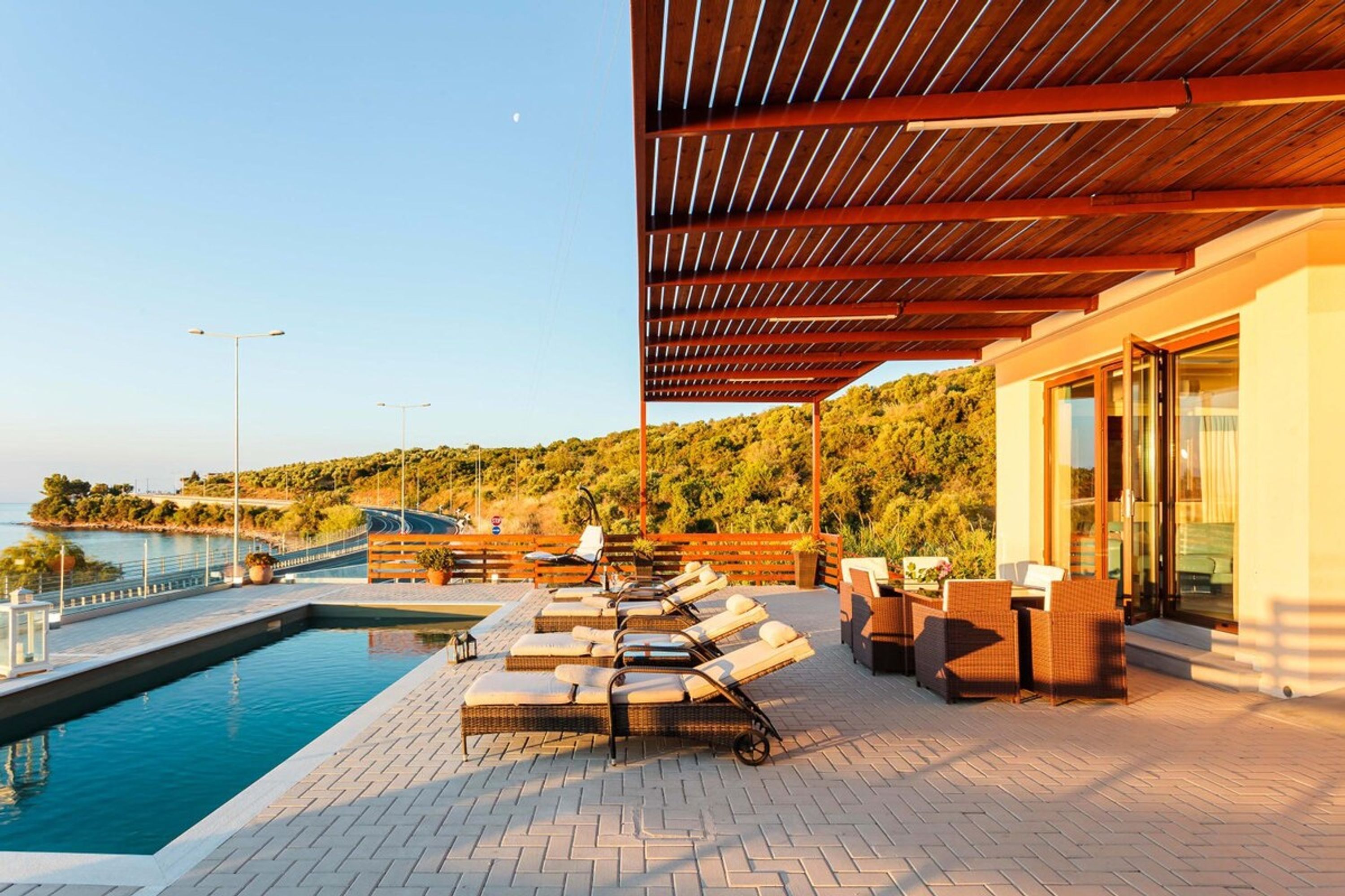 Un espace aménagé au bord de la piscine, avec des chaises longues et une pergola en bois.