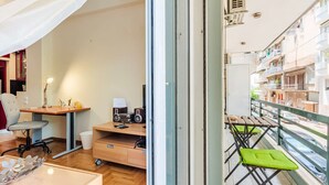 A modern apartment with a balcony, a wooden desk, a chair, a small table, and a sofa. - Athens Strawberry Hideaway - City Chic Retreat (Athens)