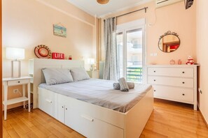 A bedroom with a bed, bedside tables, a dresser, and a window with curtains.