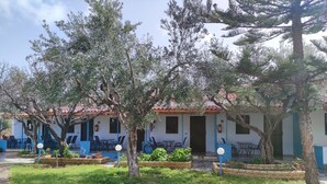 A building with a tiled roof, outdoor seating, and a garden area. - Sunny Summer Retreat - Perfect Location BBQ (Pylos-Nestoras)