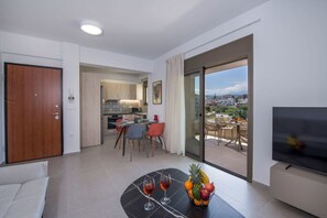 A modern living room with a dining area, a kitchen, and a balcony with a city view. - A Heaven View Park Hideaway - Chania Nest (Chania)
