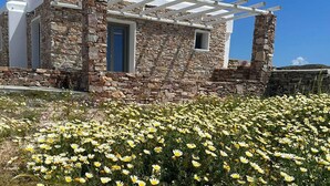 A stone building with a white exterior and a pergola. - Rustic Stone House in the Heart of Folegandros (Folegandros)