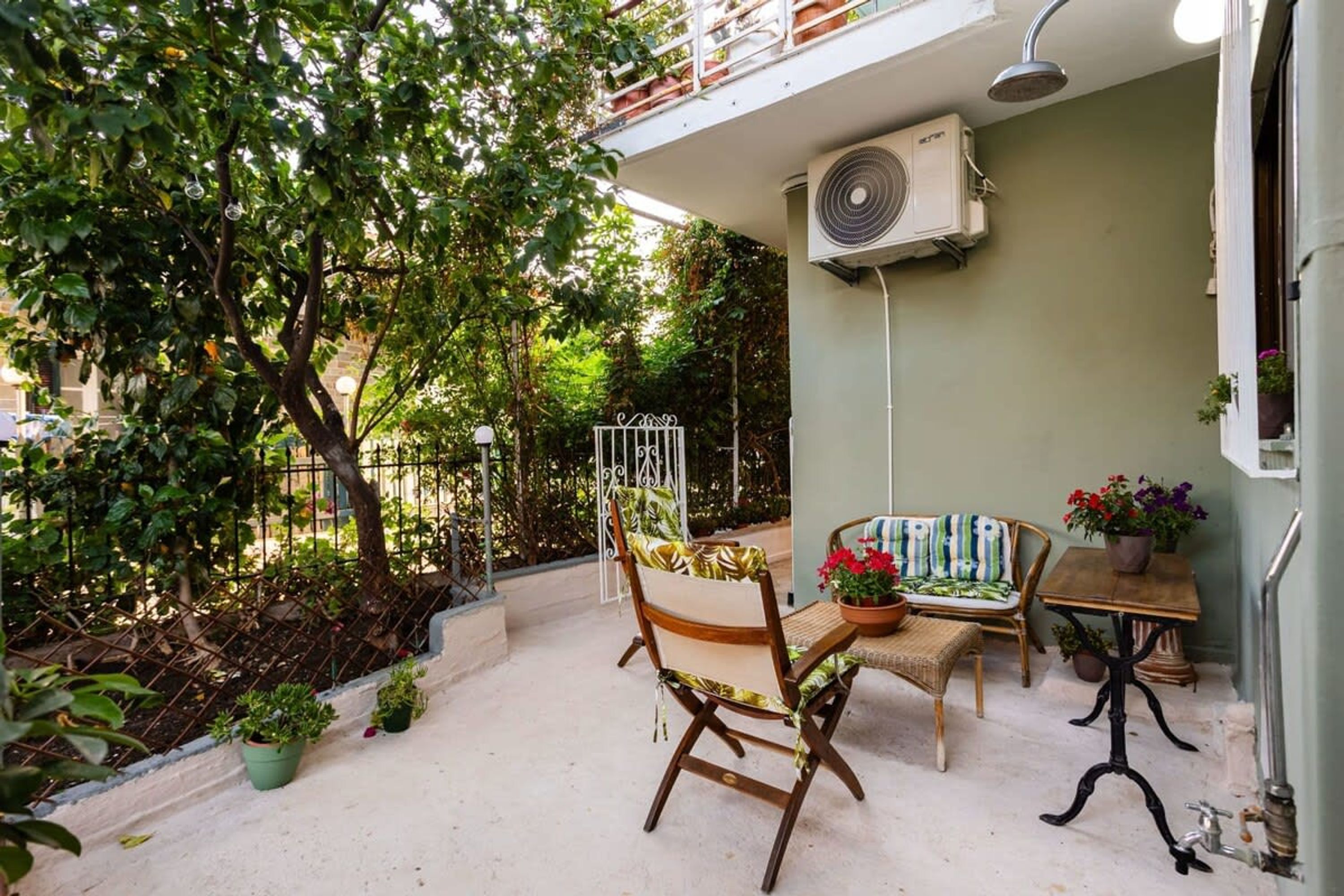 A patio with a chair, a small table, and potted plants.