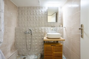 A bathroom with a shower, a sink, and a mirror. - Escape to Kalamata s Old City Your Urban Oasis (Kalamata)