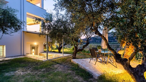 Une maison moderne dotée d’un patio, d’un espace salon extérieur et offrant une vue sur le paysage environnant.