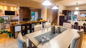 A modern living room with a dining area, a kitchen, and a staircase. - Sunset Paradise - Verga s Ultimate Seaview Getaway (Kalamata)