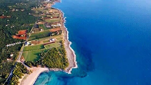 An aerial view of a coastal area with a beach, clear blue waters, and surrounding greenery. - Navarino Captains Villa - Lux Private Pool Retreat (Trifylia)