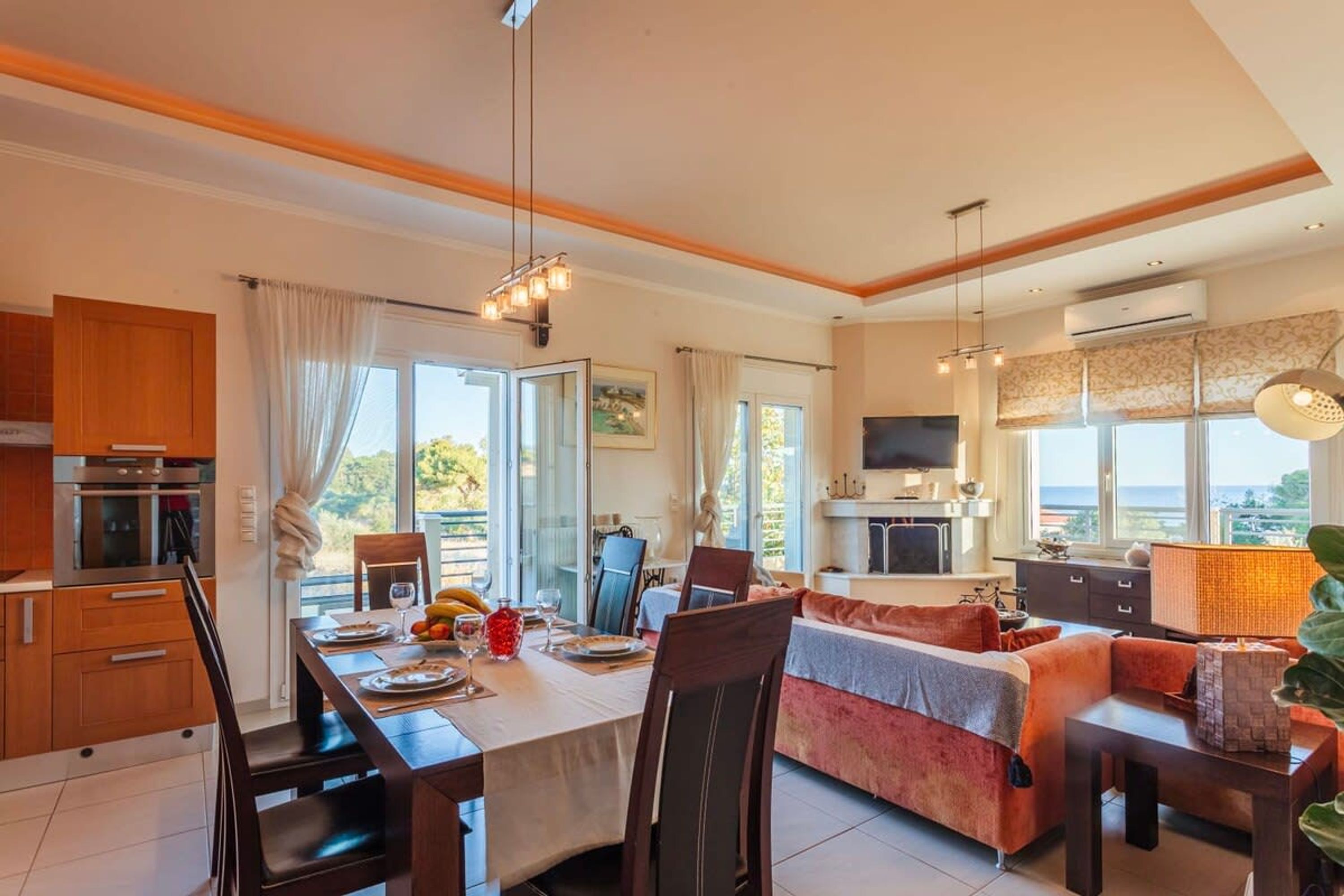 A spacious living area with a dining table, sofa, and TV.