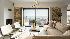 Ein modernes Wohnzimmer mit einer Wand aus Stein, einem Sofa, einem Couchtisch und einem Fernseher.