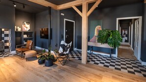Ein modernes Interieur mit einem Schachbrettfußboden, Holzbalken und Blumentöpfen.