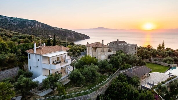 A coastal property with a white building, a stone structure, and a swimming pool. - Kitries Summer Getaway - Eden Sandy Suite (West Mani)