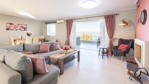 Ein modernes Wohnzimmer mit grauem Sofa, einem Holztisch und einem Kamin.