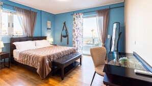 Ein Schlafzimmer mit Bett, Sitzbank, Stuhl und Schreibtisch mit Vase.