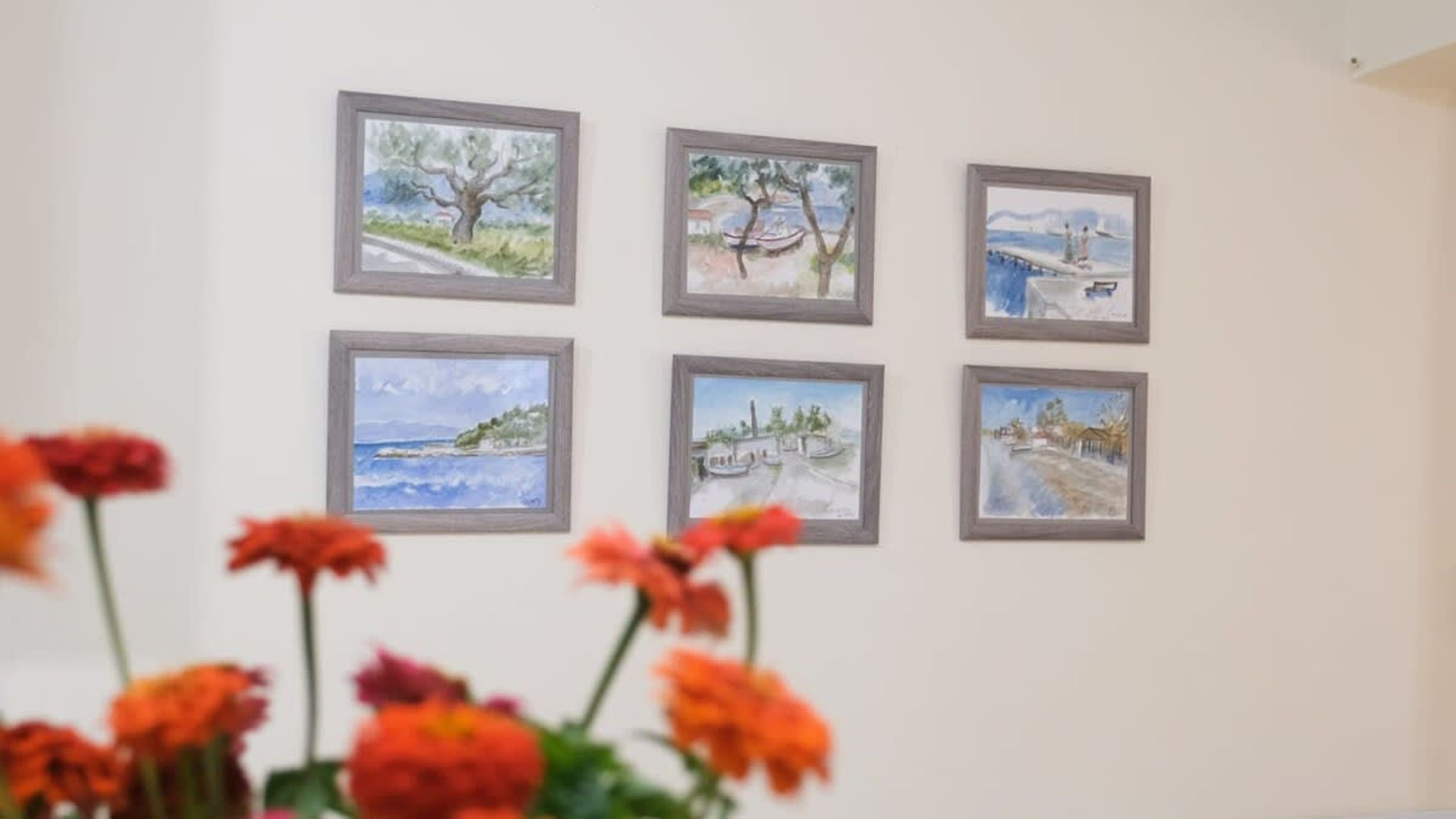 Sechs gerahmte Gemälde an einer Wand.