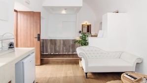 A modern kitchen with a wooden door, a white countertop, and a built-in dishwasher. - Santorini Luxury Suite w Rooftop Hottub Seaview (Santorini)