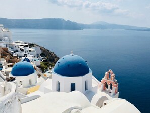 Experience the charm of a traditional Greek village with its white-washed buildings and blue domed roofs.
