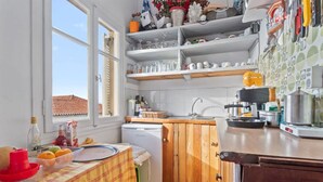 A compact kitchen with a wooden countertop, a built-in sink, and a window providing natural light. - Vibrant Spetses - Mata Colorful Nest (Spetses)
