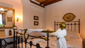 A neatly made bed with white linens, a brass headboard, and a mirror with a decorative frame. - Eros Cozy Perfect Location Panoramic sea View (Pylos-Nestoras)