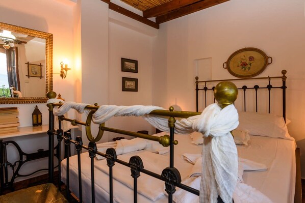 A neatly made bed with white linens, a brass headboard, and a mirror with a decorative frame. - Eros Cozy Perfect Location Panoramic sea View (Pylos-Nestoras)