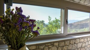 A vase with purple flowers on a windowsill.