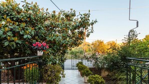 A garden pathway with potted plants and a metal railing. - Stylish Seaside Home - Fully Equipped big Terrace (Kalamata)