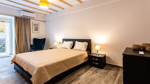 A bedroom with a bed, bedside tables, a chair, and a desk. - Valira Cozy Maisonette - Relaxing Vibes Getaway (Messini)