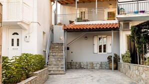 A two-story building with a stone staircase leading to a balcony. - Valira Cozy Maisonette - Relaxing Vibes Getaway (Messini)