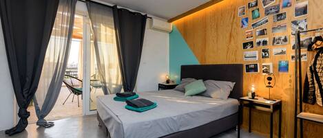 Een moderne slaapkamer met een groot bed, een wand van hout en uitzicht op het groen.