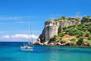 A sailboat near a rocky coastline with clear blue waters. - Eros Home Perfect Location Panoramic sea View (Pylos-Nestoras)
