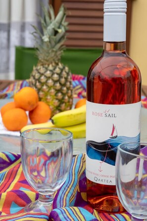 A bottle of Rose Sail wine with a label featuring a sailboat and a pineapple in the background.