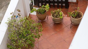 A terrace with potted plants and a black gate. - Cretan Magnolia Gem - Smari Cozy Getaway (Minoa Pediada)