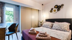 A modern hotel room with a bed, a desk, and a chair. There are towels on the bed and a decorative wall piece above it. - Urban Living Minicasa Nomad - Kalamata s Hideaway (Kalamata)