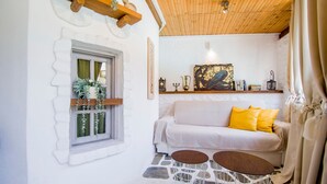 A cozy room with a white sofa, yellow pillows, and a wooden ceiling.