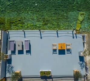 An aerial view of a rooftop terrace with a pool, seating area, and potted plants. - Seafront Karma Luxury - An Escape From Reality (South Pelion)