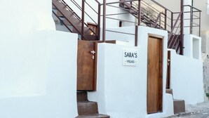 A white building with a wooden door and a sign that reads "SARA'S VILLAS." - Santorini Rooftop Hot Tub Suite w Panoramic Views (Santorini)