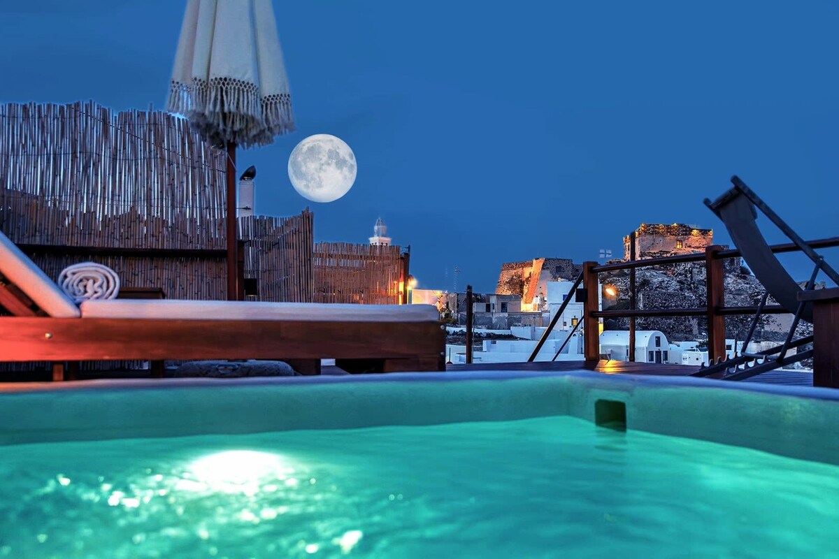 A hot tub with a wooden deck and a wooden fence in the background.