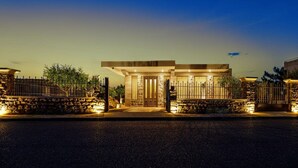 A modern house with a stone facade, a large front door, and a gated entrance. - Lithos Messolongi Paradise - A Luxurious Retreat (Mesolongi)